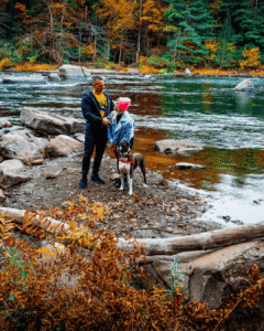 Courtney and Nick with their boxer Roman beside the Youghiogheny River at Ohiopyle State Park during peak fall foliage