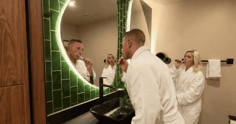 Couple in hotel robes getting ready in the bathroom