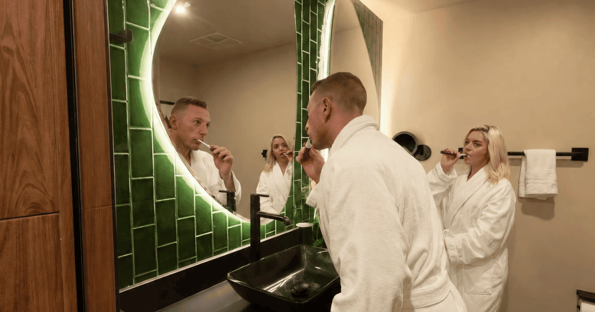 Couple in hotel robes getting ready in the bathroom