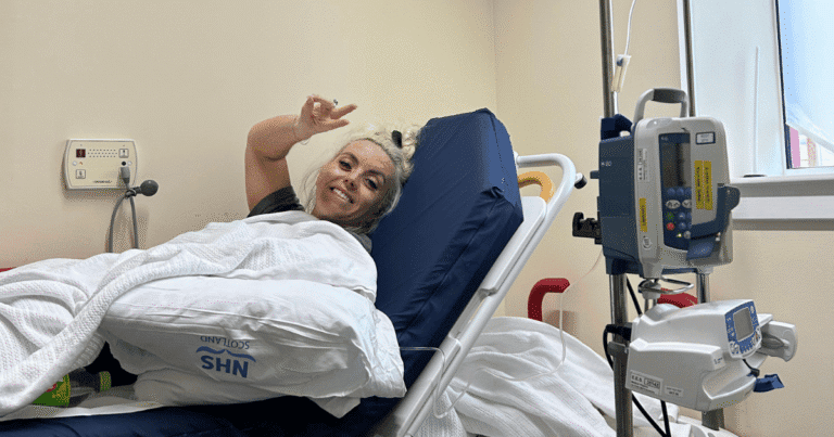 Courtney on a hospital bed with an IV drip after being treated for E. coli in Inverness, Scotland