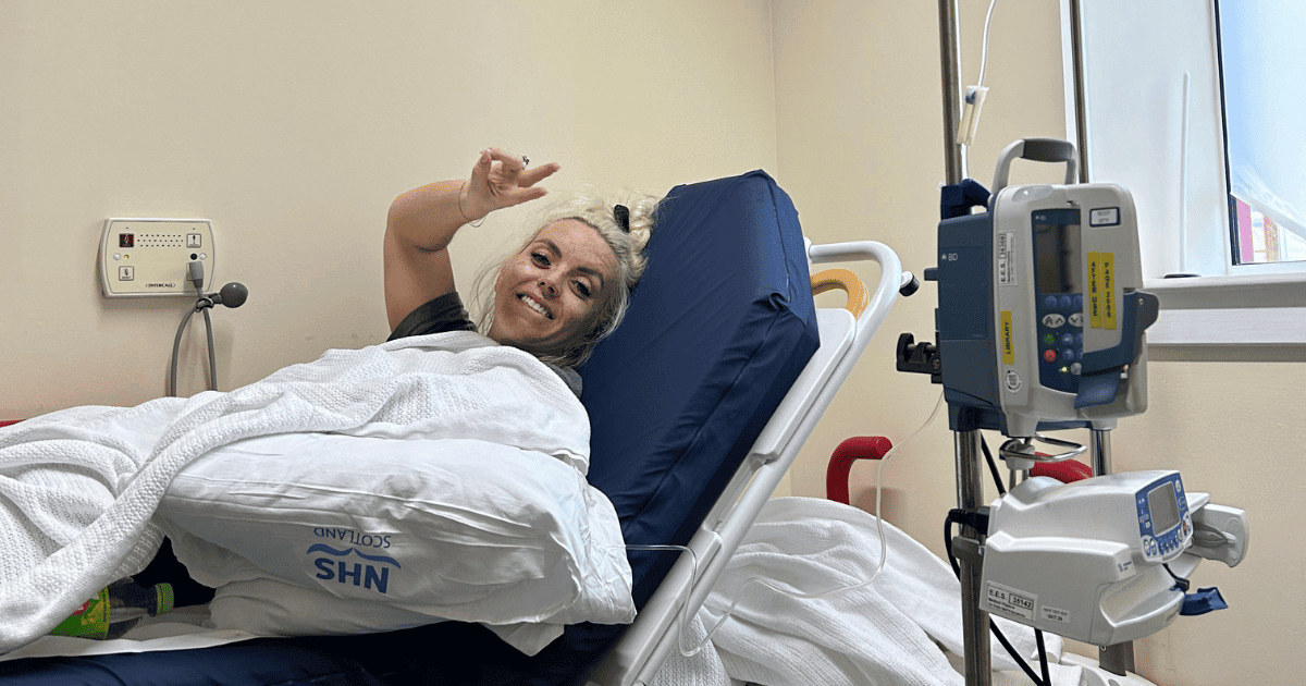 Courtney on a hospital bed with an IV drip after being treated for E. coli in Inverness, Scotland